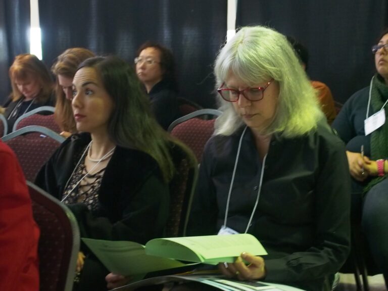 CCL attendees looking through handouts and listening to speakers.